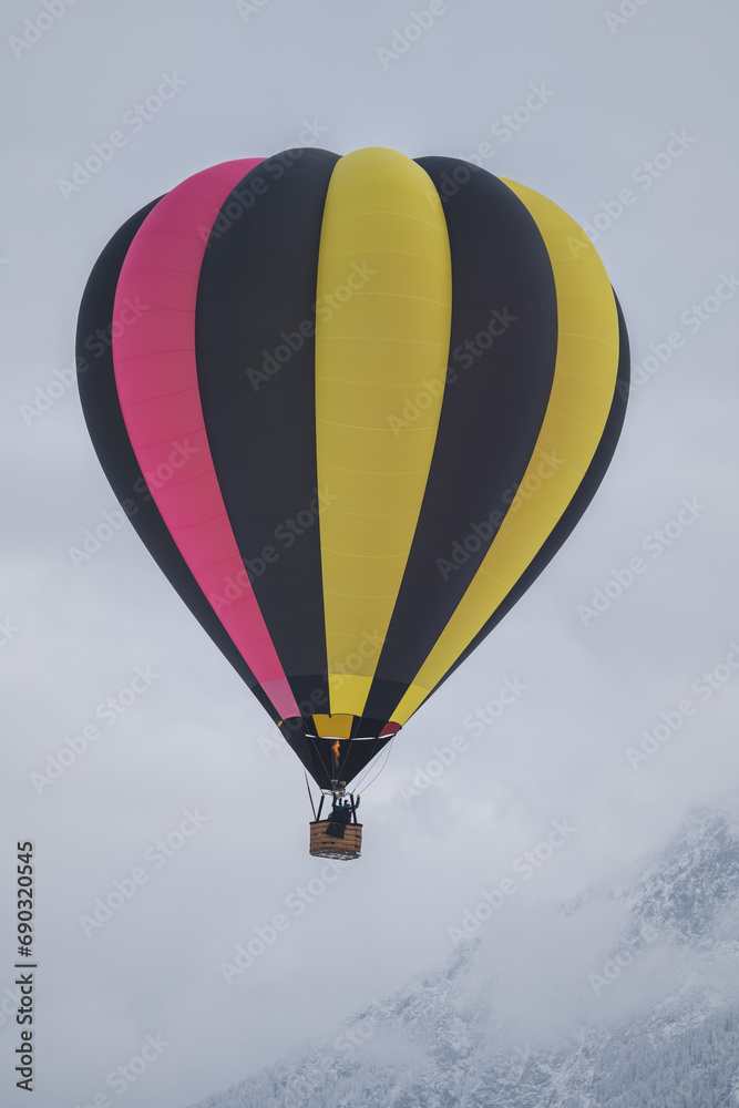 Fototapeta premium Bunter Heißluftballon in Winter Berglandschaft