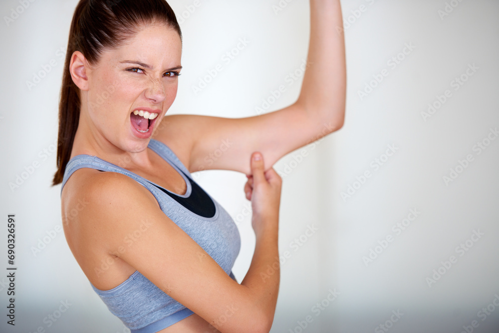 Fitness, arm and woman holding her fat for health, wellness and weight loss goals in a studio. Shout, scream and portrait of young female person showing bicep body for exercise or workout motivation Fitness, arm and woman holding her fat for health, wellness and weight loss goals in a studio. Shout, scream and portrait of young female person showing bicep body for exercise or workout motivation