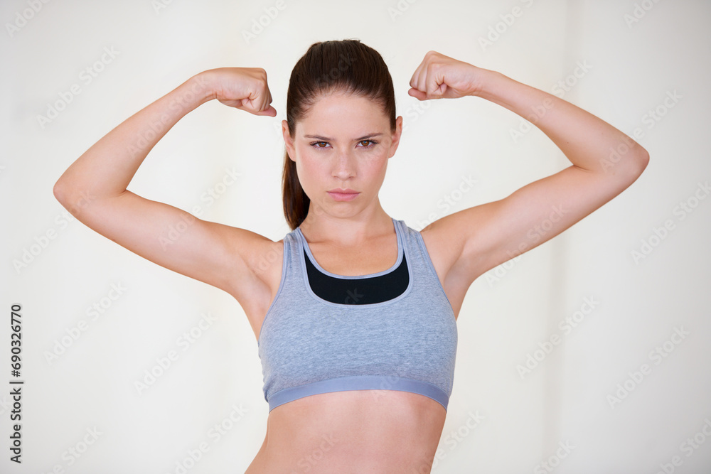 Woman, portrait or serious in studio with flex for fitness, wellness or workout strength with sportswear. Person, athlete or pride for biceps, exercise or training on white background or mockup space Woman, portrait or serious in studio with flex for fitness, wellness or workout strength with sportswear. Person, athlete or pride for biceps, exercise or training on white background or mockup space