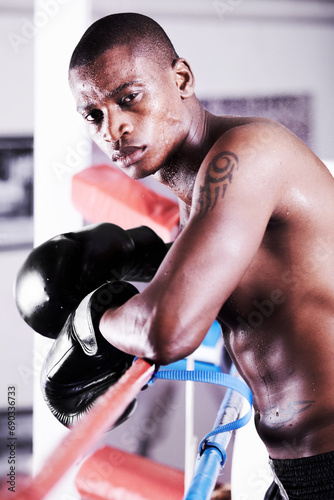 Boxing, gloves and portrait of black man in ring with fitness, power and workout challenge at sports club. Strong body, face of athlete or boxer in gym with sweat and confidence in competition fight.