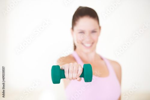 Woman, hand and dumbbell portrait for gym exercise or workout challenge, fitness training for performance practice. Female person, face and smile or strong weight lifting, progress on wall background