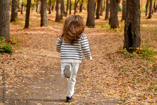 A beautiful teenage girl with long hair smiles and runs in an autumn park. Togliatti, Russia - 30 Sep 2023 © KseniaJoyg