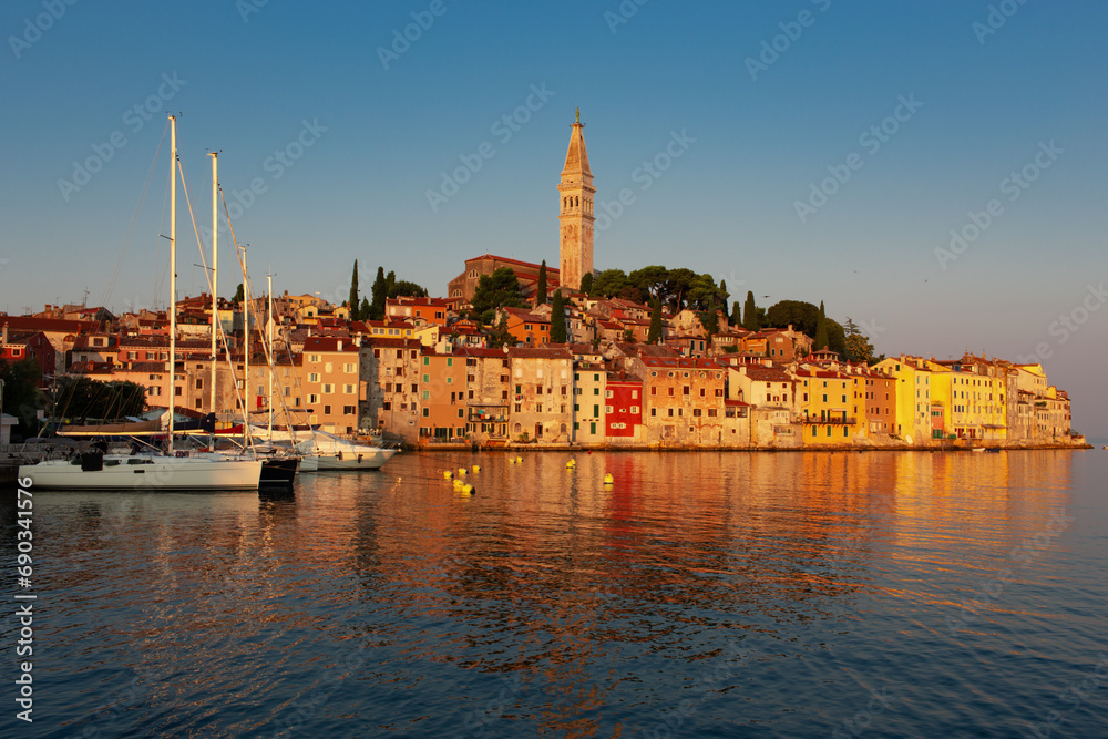 morning view of old  Rovinj town with multicolored buildings and yachts moored along embankment, Croatia.