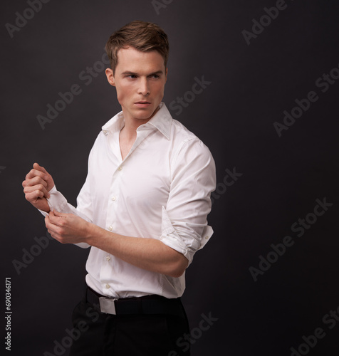 Fashion, studio man and thinking of fancy clothes for semi formal outfit, attire or confident in classy, elegant or stylish apparel. Fix dress shirt, mockup space or model choice on black background photo