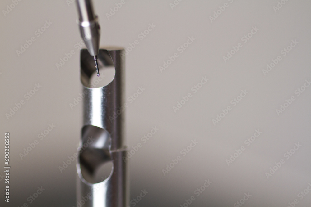 CMM Programming Probe by Small Metal Part on White Background Close-Up CMM Programming Probe by Small Metal Part on White Background Close-Up