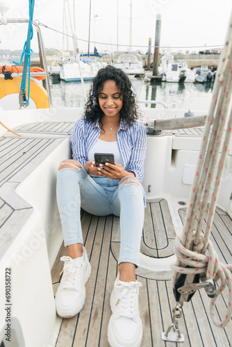 Woman using smartphone on yacht