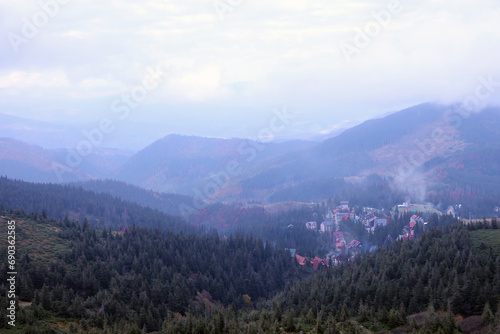 Morning view of residental area and houses around the Dragobrat mountain peaks in Carpathian mountains, Ukraine. Cloudy and foggy landscape around Drahobrat Peaks in early morning
