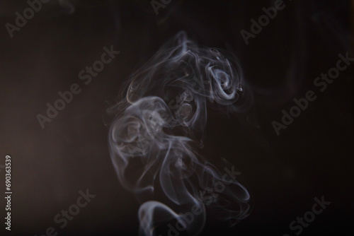 Ethereal Dance of Incense Smoke against Dark Background