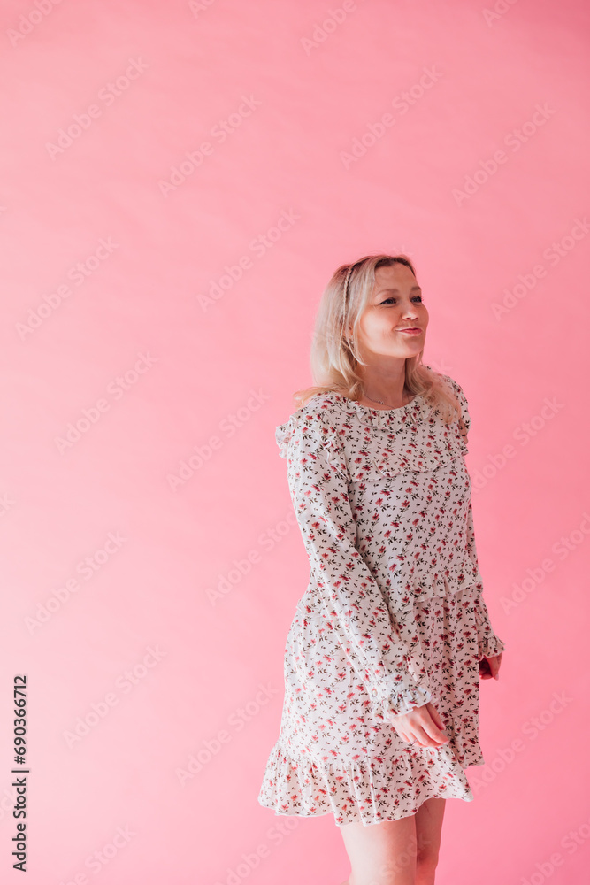 Beautiful blonde woman in summer light dress on pink background Beautiful blonde woman in summer light dress on pink background