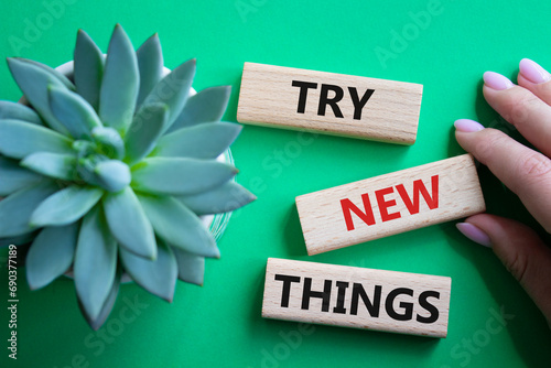 Try new Things symbol. Concept words Try new Things on wooden blocks. Businessman hand. Beautiful green background. Business and Try new Things concept. Copy space.