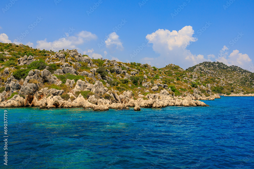 Fototapeta premium View of the rocky shore from the sea. Mediterranean Sea in Turkey. Popular tourist places. Background