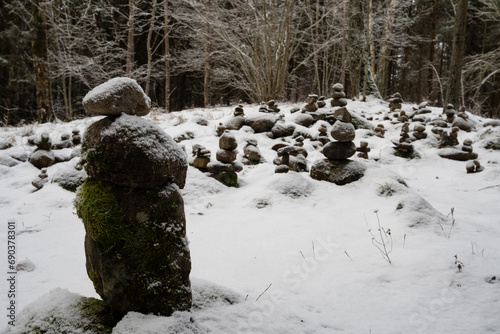 Snow-Drifted Secrets: Mossy Stacked Rocks Concealed in Pokainu Mezs' Snowy Wilderness photo