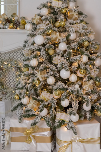 Decorated Christmas tree with golden ornament,balls and big gift presents for new year.A lot of packing handmade gift boxes lying under tree.winter holidays