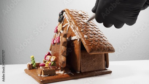 Christmas gingerbread in the shape of a house. Assembling a gingerbread house before Christmas with sugar icing.
