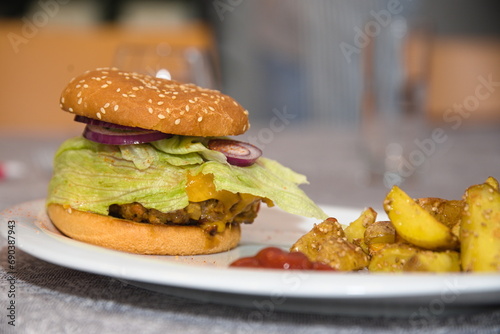 frisch zubereiteter Burger mit Kartoffelspalten photo