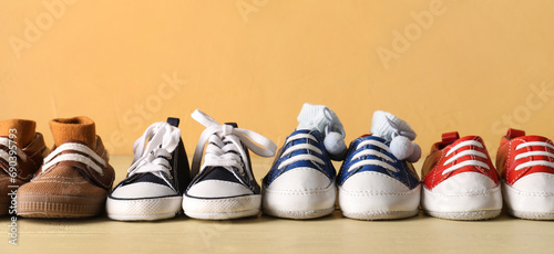 Set of different baby booties on yellow background