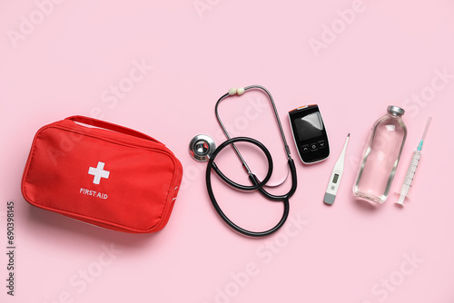 First aid kit on pink background