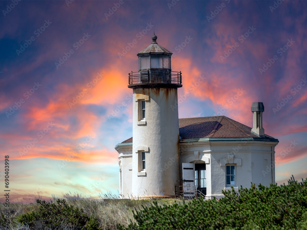Coquille River Lighthouse along the Oregon Coast with a dramatic sky at sunset.