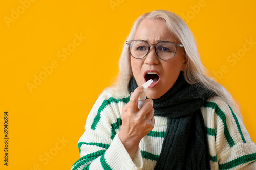 Ill mature woman using spra...