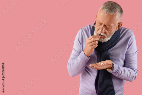 Sick mature man taking pill...