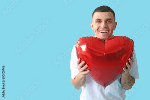 Happy young man holding red...