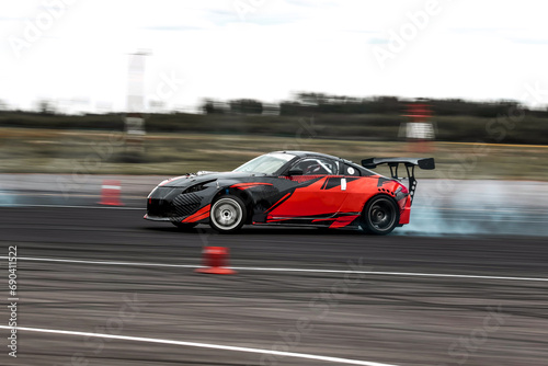 Red Sports Car Drifting Around Racetrack Corner At Speed © AvokadoStudio