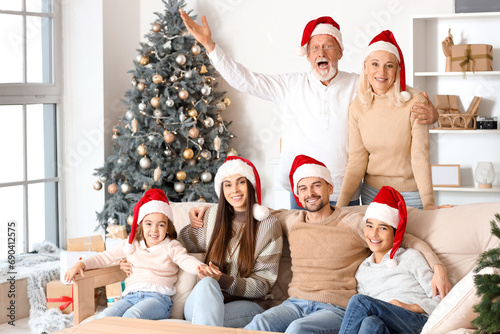 Big family in Santa hats at home on Christmas eve