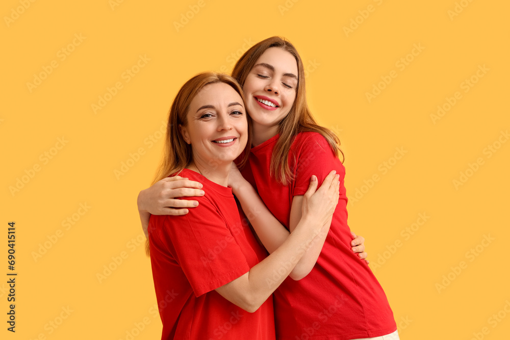 Happy young woman hugging her mother on yellow background. International Hug Day Happy young woman hugging her mother on yellow background. International Hug Day