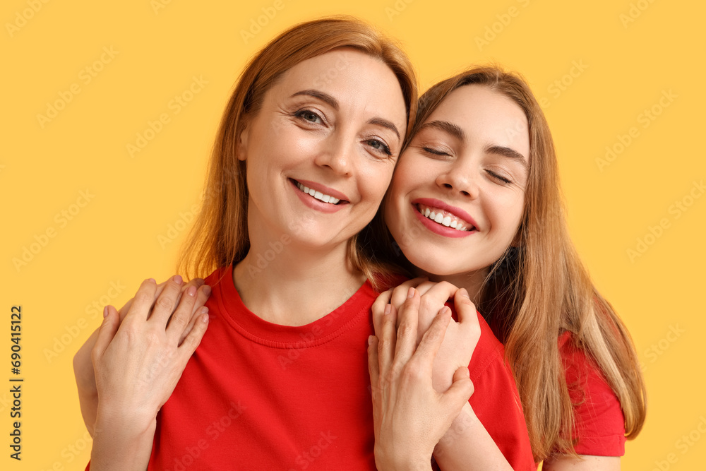 Happy young woman hugging her mother on yellow background. International Hug Day Happy young woman hugging her mother on yellow background. International Hug Day