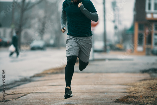 Young man running in rainy weather photo