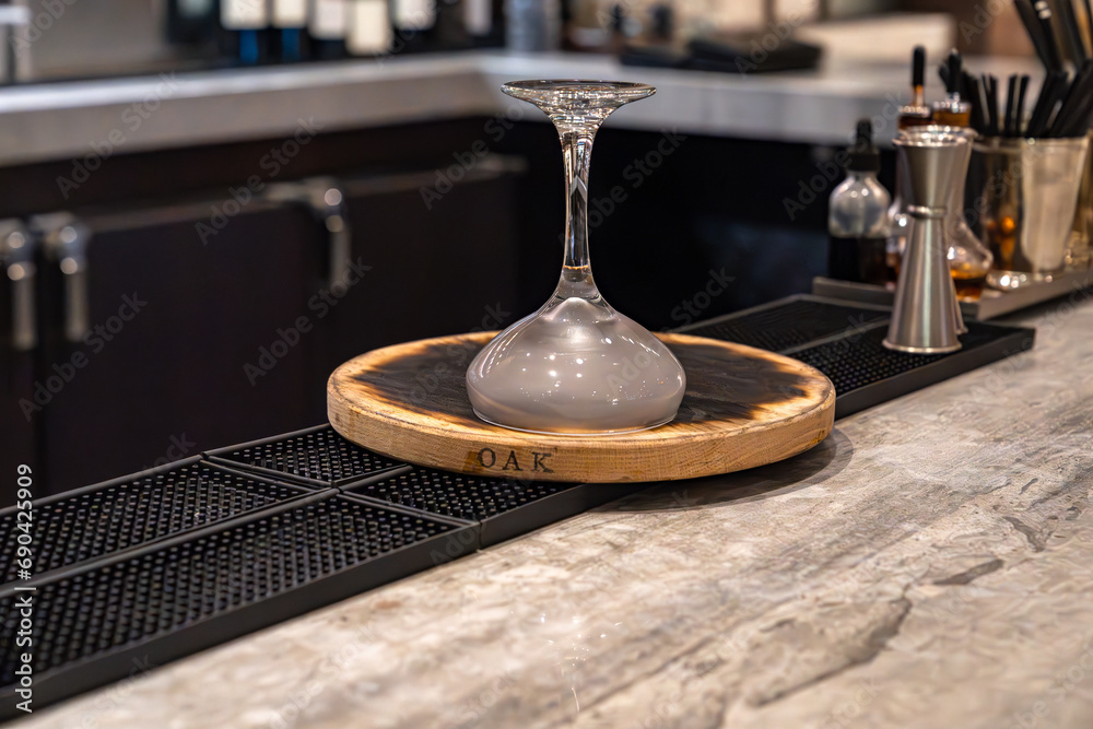 Obraz premium Oak whiskey smoker with upside down cocktail glass in a bar