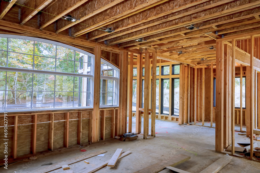 An new construction home with wooden framing beams attached to framework