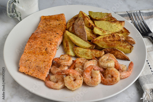 seasoned salmon  served with shrimp and potato wedges, photo