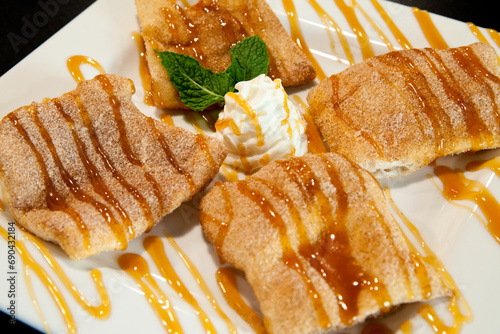Sopapillas, Crisp Cinnamon Pastries Drizzled with Caramel on White Plate photo