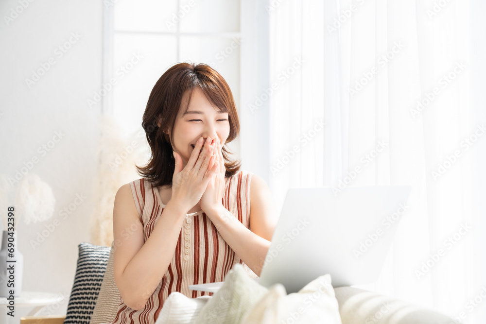 部屋でラップトップコンピューターを見る女性 部屋でラップトップコンピューターを見る女性