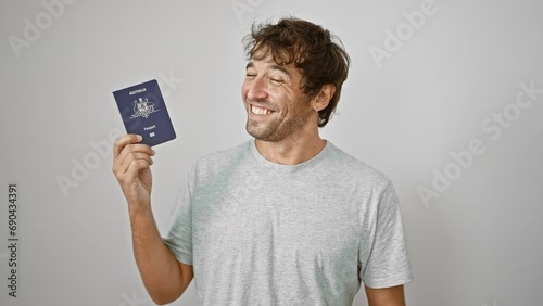 Confident, happy young man joyfully holds his australian passport, smiling against an isolated white background, ready for his next holiday adventure photo