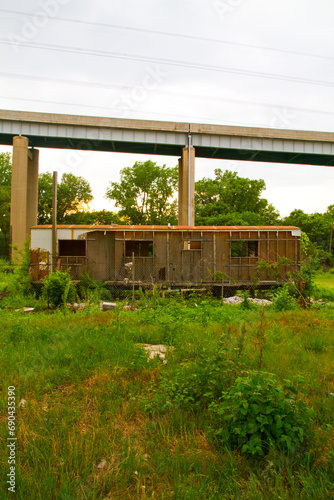 Sunset Over Abandoned Urban Building in Illinois with Overgrown Vegetation and Bridge View