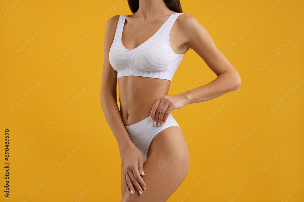 Young woman in stylish white bikini on orange background, closeup Young woman in stylish white bikini on orange background, closeup