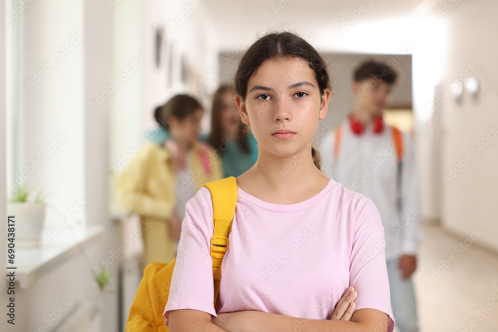 Teen problems. Lonely girl standing separately from other students at school Teen problems. Lonely girl standing separately from other students at school