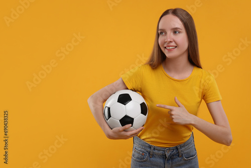 Happy sports fan with ball on yellow background. Space for text © New Africa