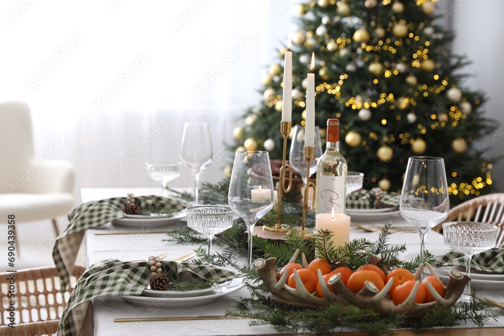 Christmas table setting with festive decor and dishware in room Christmas table setting with festive decor and dishware in room