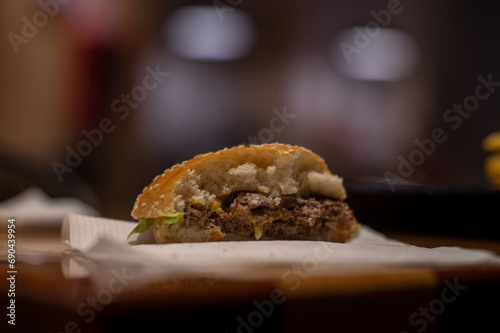 Hamburguesa con queso a medio comer aislada en un restaurante de comida rápida