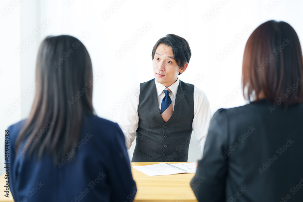 塾の講師と面談をする生徒と保護者 塾の講師と面談をする生徒と保護者