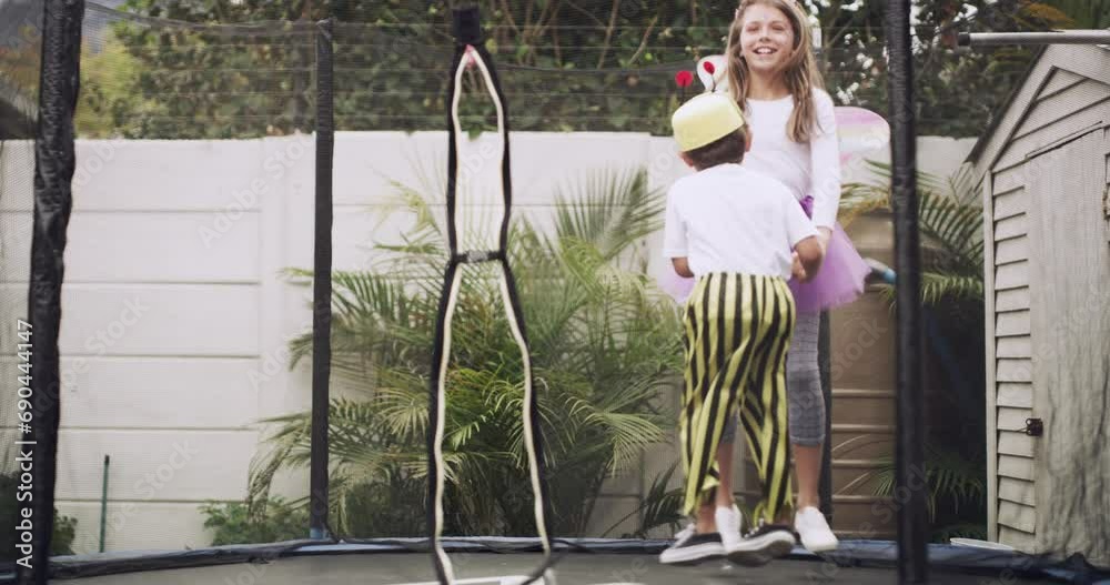 Happy children, costume and jumping on trampoline in backyard together