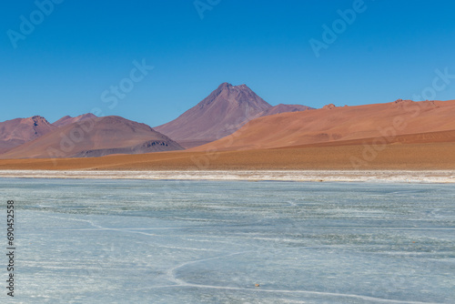Landscape with frozen lagoon and volcano in the background, in the Atacama Desert