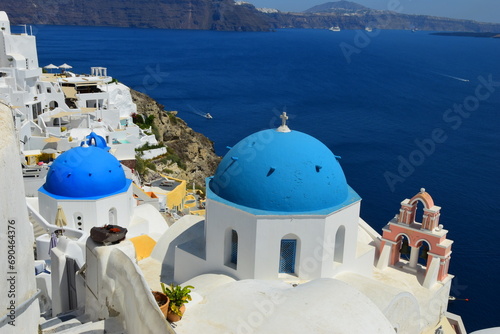 Fototapeta Naklejka Na Ścianę i Meble -  SANTORINI,GREECE-June 20 2023: Oia village, the most picturesque village on Santorini island, a famous touristic resort in the Cyclades islands, Aegean sea, Greece, Europe. This was on a hot sunny day