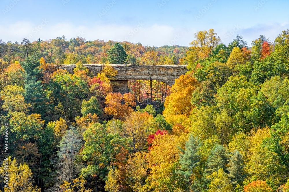 Colorful autumn leaves surround Natural Bridge, a beautiful sandstone rock arch in a state park in the Red River Gorge geologic region of Kentucky, the Bluegrass State. Colorful autumn leaves surround Natural Bridge, a beautiful sandstone rock arch in a state park in the Red River Gorge geologic region of Kentucky, the Bluegrass State.