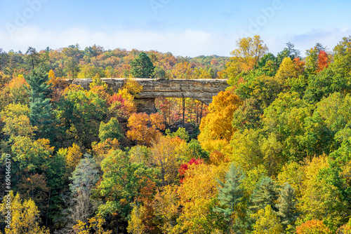 Colorful autumn leaves surround Natural Bridge, a beautiful sandstone rock arch in a state park in the Red River Gorge geologic region of Kentucky, the Bluegrass State.