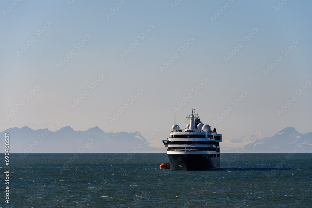 Large cruise ship in the calm ocean outside Longyearbyen, Svalbard in the arctic early in the morning on a summer day
