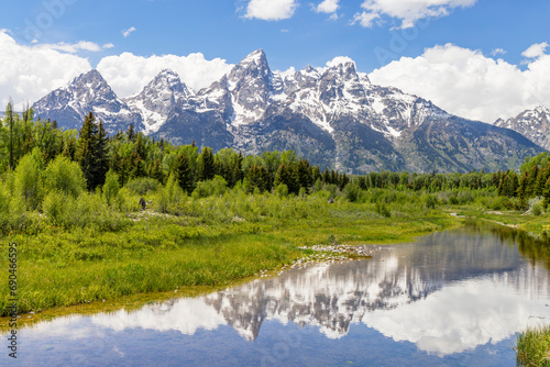 The snow-capped peaks of the Cathedral Group of the Teton Mountain Range rise above the Snake River Valley at Schwabacher s Landing  Grand Teton National Park  Wyoming.